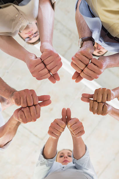 istock Business team gesturing thumbs up in huddle 493174081