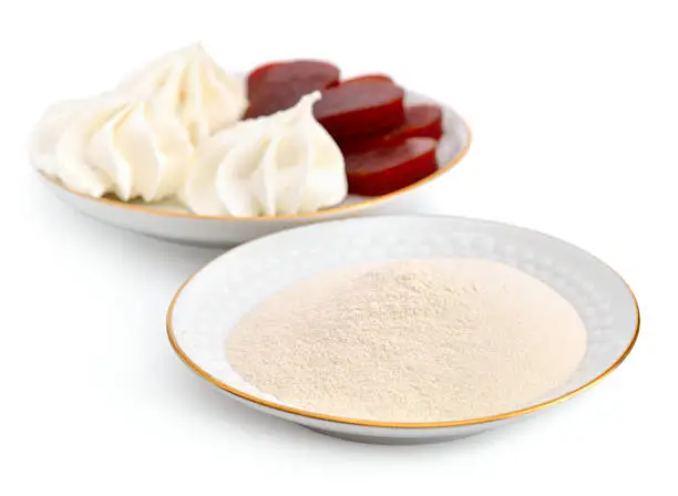 Agar-agar powder on a white plate. On a background Zefir and fruit jelly. Isolated.