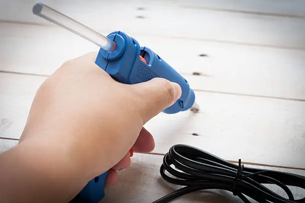 Hand holding glue gun