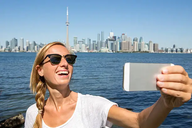 Photo of Cheerful girl takes selfie in Toronto city
