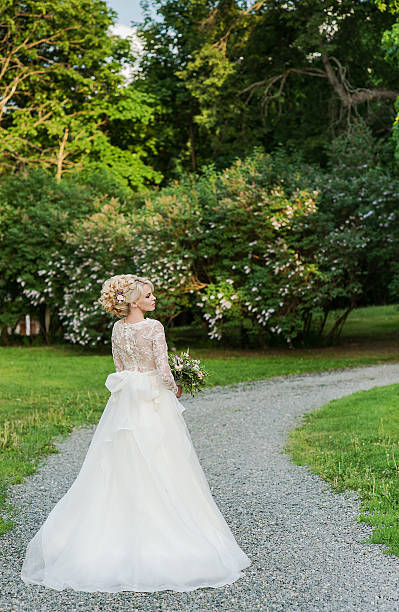 istock Beautiful blonde bride  in the Park whith wedding bouquet 493186746