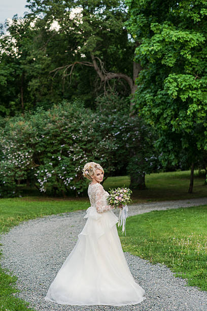 istock Beautiful blonde bride  in the Park whith wedding bouquet 493186772