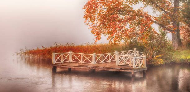 Old white wooden beautiful bathing jetty in autumn.