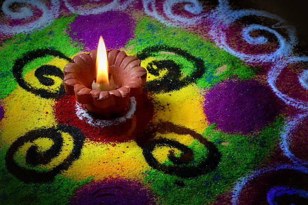 istock Clay diya lamps lit during diwali celebration. Rangoli in background 493194742