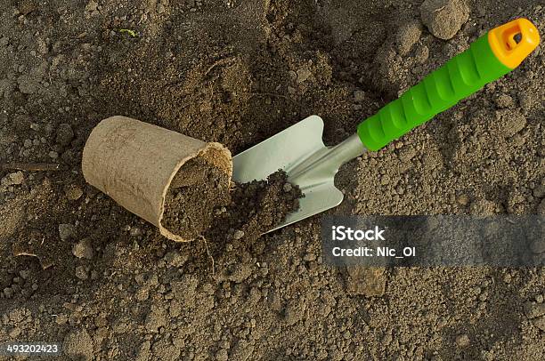 Green Shovel And Peat Pot For Seedlings In The Ground Stock Photo - Download Image Now