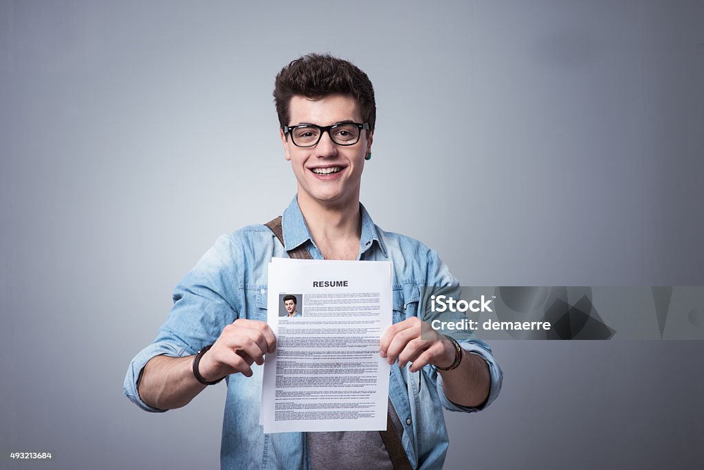 Young man with resume Young smiling man holding his resume applying for a job Résumé Stock Photo