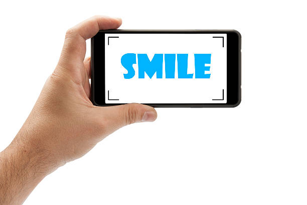 istock Human hands holding mobile phone camera with Smile 493213782