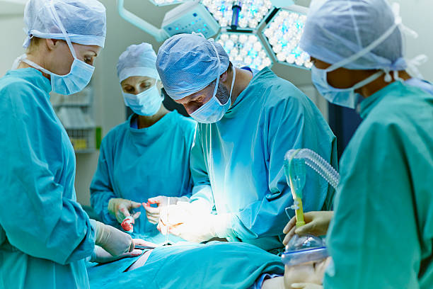 surgeons performing surgery in operating room - surgery 뉴스 사진 이미지