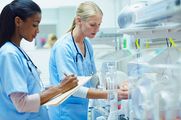 nurses monitoring baby in incubator - unknown gender foto e immagini stock