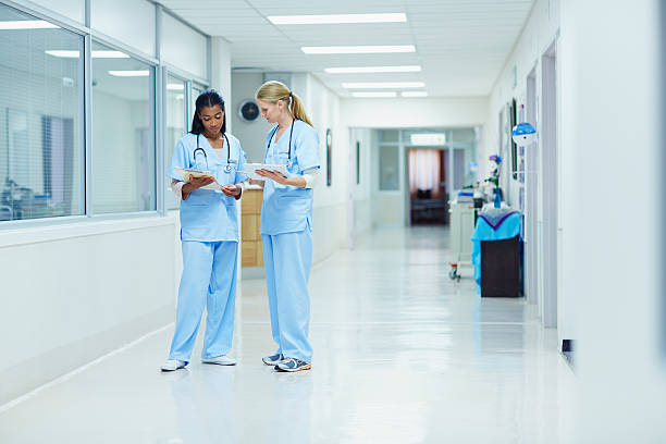 nurses discussing medical documents in hospital - medical building stock-fotos und bilder