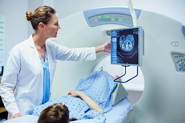 doctor showing ct scan to patient - medizinisches scannen stock-fotos und bilder