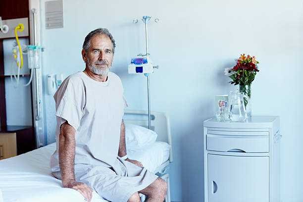 mature man in hospital ward - examination gown fotografías e imágenes de stock