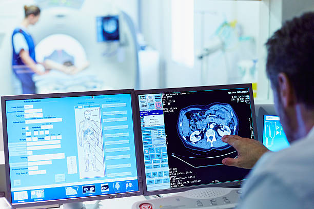 Doctor running CT scan from control room Male doctor running CT scan from control room at hospital diagnostic medical tool photos stock pictures, royalty-free photos & images