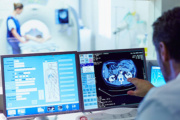 doctor running ct scan from control room - medical equipment imagens e fotografias de stock