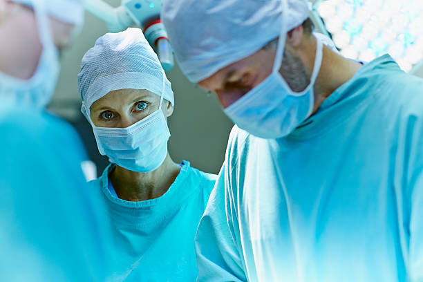surgeon with colleagues in operating room - 4679 - fotografias e filmes do acervo