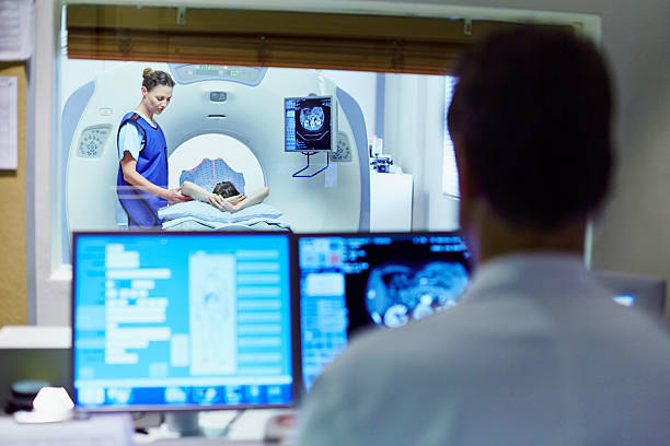 doctor preparing patient for ct scan - tomografía fotografías e imágenes de stock