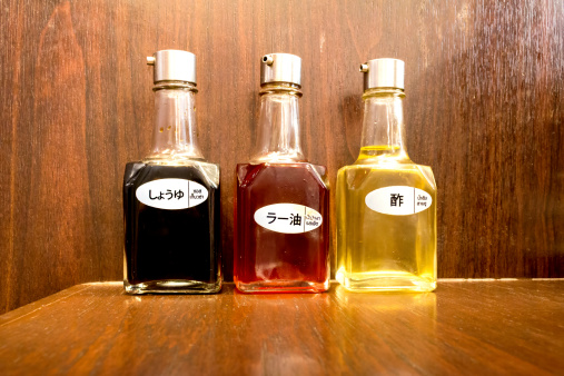 three bottles of sesame oil and choyu sauce on the wood table