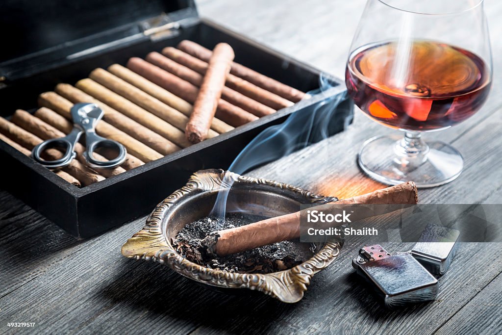 Aroma of cognac and cigar fuming Aroma of cognac and cigar fuming. Ashtray Stock Photo