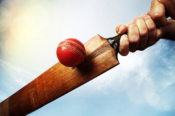 cricket-spieler schlagen ball - kricketball stock-fotos und bilder