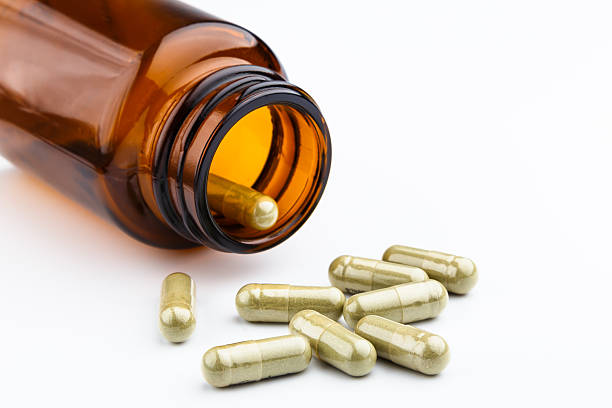 istock herb capsule spilling out of a bottle 493220065