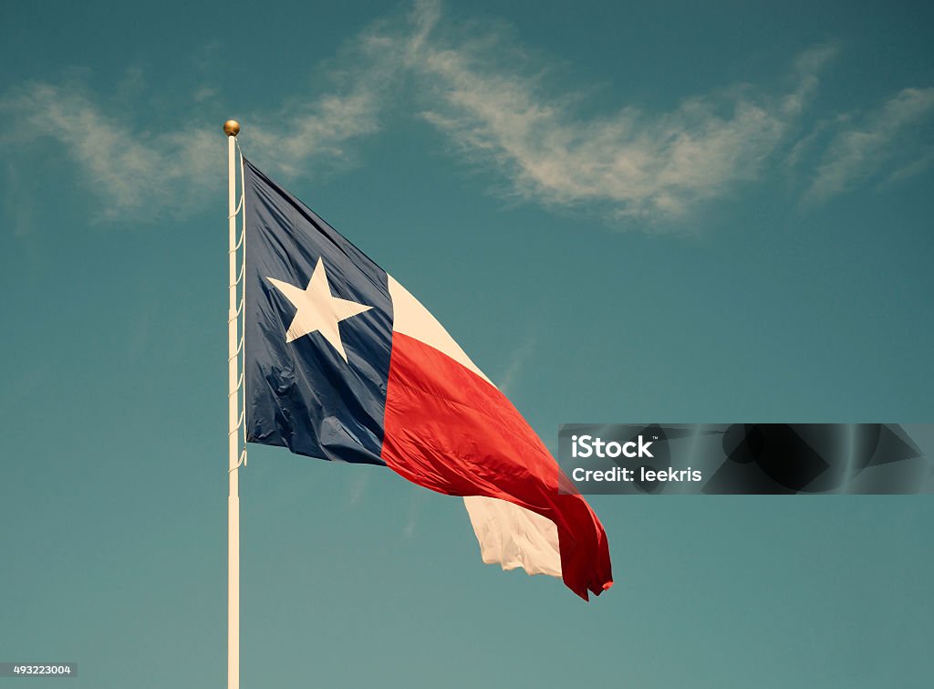 State flag of Texas against blue sky State flag of Texas against blue sky. Vintage filter effects. Texas State Flag Stock Photo
