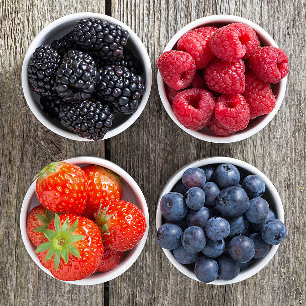 istock strawberries, blueberries, blackberries and raspberries in bowls 493224247