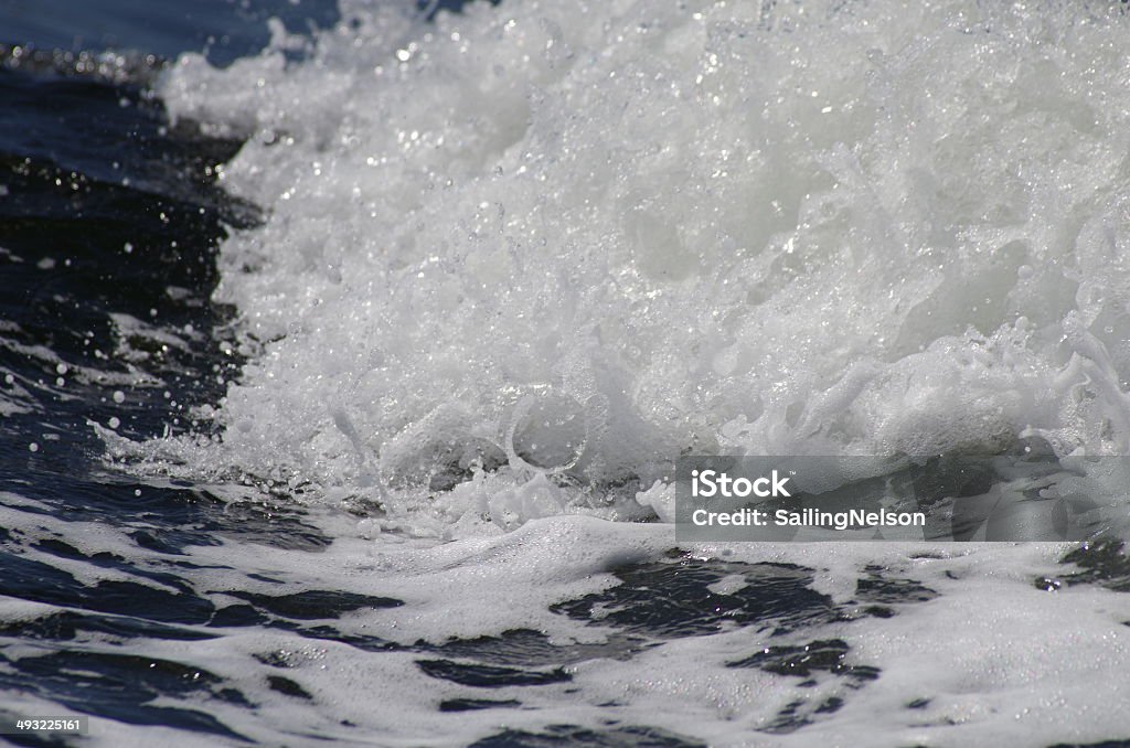 Crashing Sea Wave An ocean wave crashes into sea foam and salt spray. Beach Stock Photo