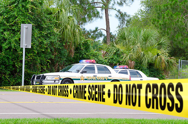 Crime scene investigation w sheriff cars and barrier tape stock photo