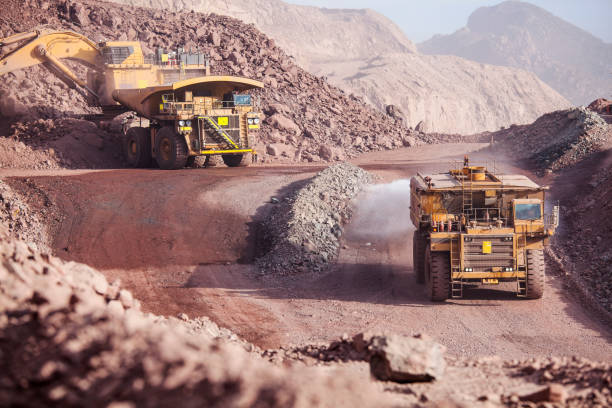Mining Trucks Loading of copper ore on very big dump-body truck and watering road tanker copper mine photos stock pictures, royalty-free photos & images