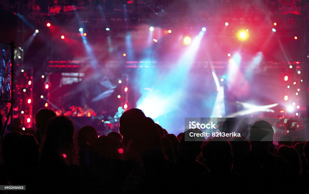 Cheering crowd at concert Cheering crowd in front of bright colorful stage lights Adulation Stock Photo