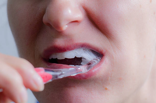 istock Close up on woman no makeup brushing her teeth 493245492