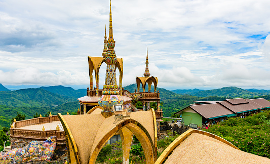 architecture of Wat Phra That Pha Son Kaew, PETCHRABOON province, THAILAND. buddhism crafts religions handwork on glass and ceramic tiles decoration on gold color pagoda surface
