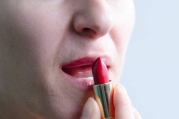istock Close up on woman putting lipstick 493246368
