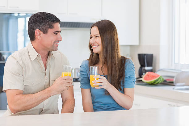 istock Smiling couple with orange juice in the kitchen 493246589