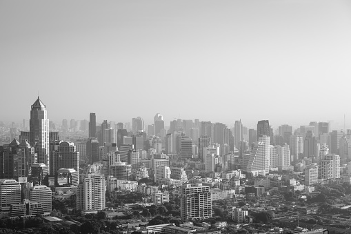 Bangkok cityscape in the morning, view from high building, sun is rising and mist is covering the city, black and white color