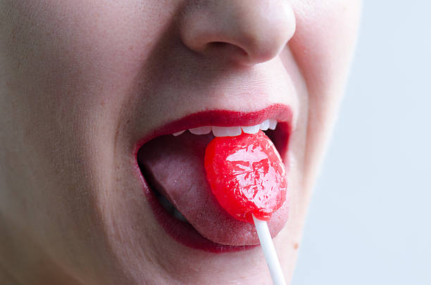 istock Close up on woman licking a red lollipop 493247556