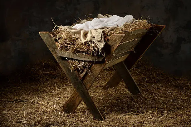 Manger with hay and swaddling clothes in old stable