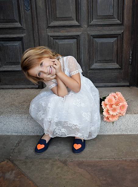 Flower girl, little bride An asorable little girl sits on the church steps with her head I  hands free wedding stock pictures, royalty-free photos & images