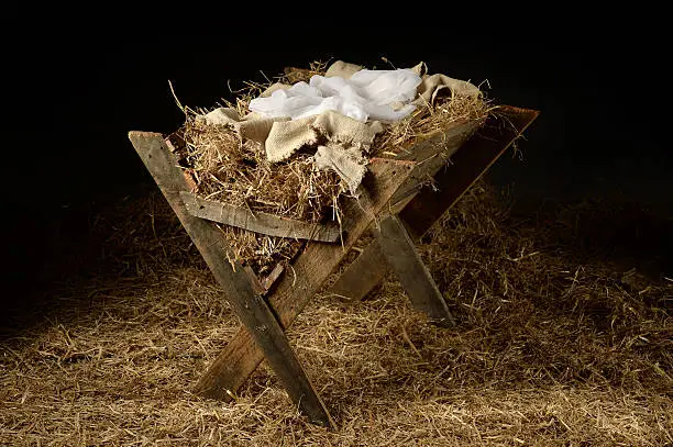 Old manger with old clothes as a symbol of waiting for Christmas