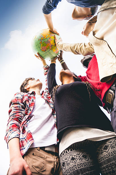 istock Group of teenagers holding an earth globe 493250231