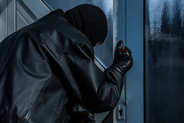 istock burgler with screwdriver at front door 493269738
