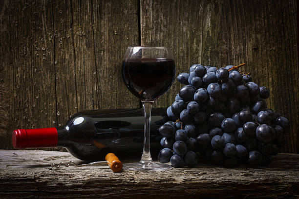 istock Bottle of red wine, grape and corkscrew on wooden table 493270254