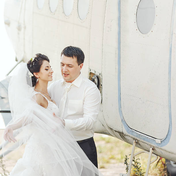 istock Wedding summer couple together posing against airplane. 493275488