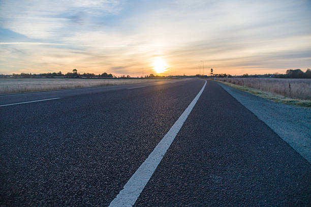 istock Empty turning asphalt road closeup and sunrise cloudscape 493276550