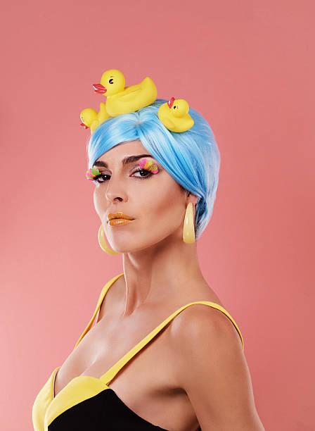 She's a woman of sophisticated style...and she likes ducks! Shot of a retro-styled woman with rubber ducks in her blue hair posing on a pink backgroundhttp://195.154.178.81/DATA/i_collage/pu/shoots/805731.jpg crazy makeup stock pictures, royalty-free photos & images