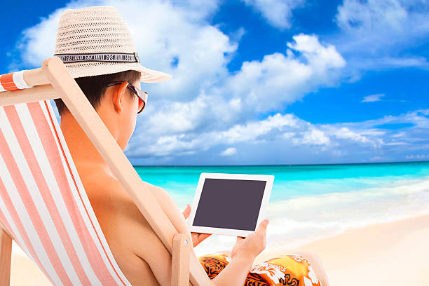 istock relaxed man sitting on beach chairs and touching tablet 493279189