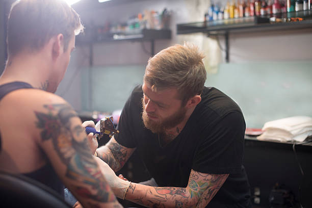 istock Artist making tattoo on man's hand in studio 493279294