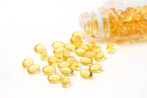 istock vitamin capsules with  E poured out of bottle 493279351