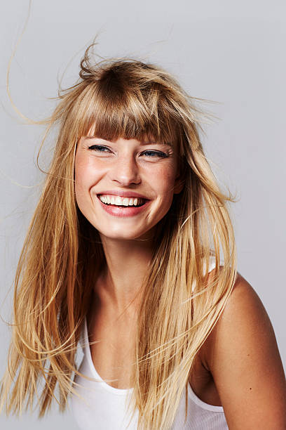 mujer joven sonriente en el estudio - long hair fashion model women blond hair fotografías e imágenes de stock