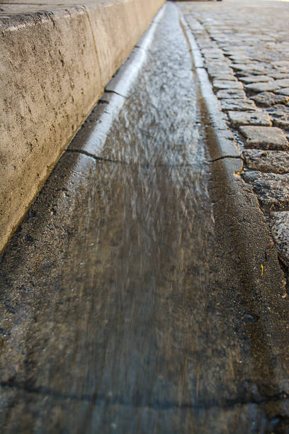 istock Flowing rain water near the road 493282659